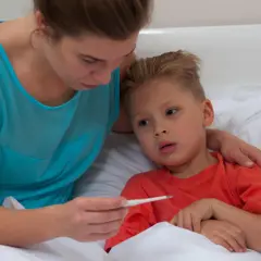 Mamma controlla la febbre al bambino, preoccupata per la quarta malattia.