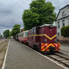 Czerwona lokomotywa z wagonami na stacji w Piasecznie. Idealne piaseczno atrakcje na weekend dla miłośników kolei.