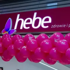 Logo Hebe z motylem i girlanda różowych balonów.