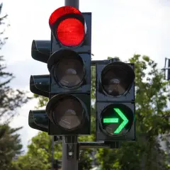 Sygnalizacja świetlna z czerwonym światłem na górze i zieloną strzałką po prawej. Czas jechać!