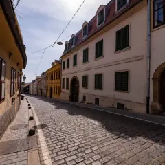 Brukowana uliczka w Zagrzebiu, z kamiennymi domami i latarnią. Odkryj urokliwe zagrzeb atrakcje spacerując tymi uliczkami.