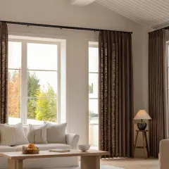 These rich brown curtains frame large windows, showing that curtains are far from out of style, adding warmth and texture to a modern living room.