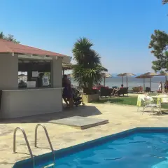 Basen i bar przy plaży w Hotel Rachoni Resort. Słońce, palmy i morze tworzą idealne wakacje.