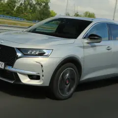 Srebrny DS 7 Crossback E-Tense pędzi autostradą, jego elegancka linia podkreślona przez dynamiczne światła.