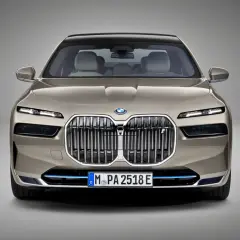 Przód luksusowego BMW Serii 7 w kolorze szampańskim. Charakterystyczny grill, smukłe reflektory LED. Szczegółowe bmw 7 dane techniczne dostępne online.