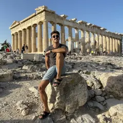 Hombre sentado en la Acrópolis, disfrutando de la vista del Partenón. ¡Una parada obligatoria si buscas qué ver en Atenas en 2 días!
