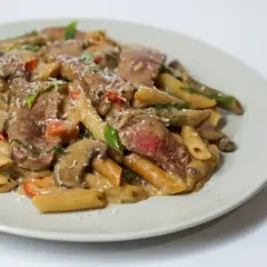 Penne z kawałkami soczystej wołowiny w kremowym sosie z pieczarkami i pomidorkami. Idealne, co w piątek na obiad zamiast ryby.