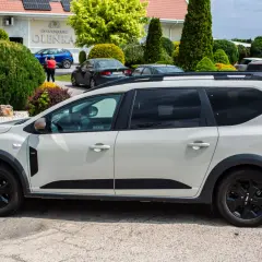 Jasnoszary Dacia Jogger na parkingu. Zastanawiasz się nad jego spalaniem? Ten rodzinny samochód oferuje przestronność i praktyczność.