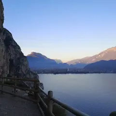 Spacer po ścieżce na zboczu Monte Brione z widokiem na jezioro i góry.