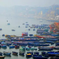 Łodzie na rzece Ganges, w tle mgliste miasto i świątynie.