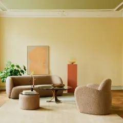Gemütliches Wohnzimmer mit Bouclé-Möbeln und einem Kunstwerk. Die Decke wurde in einem frischen Grün gestrichen, was dem Raum eine besondere Note verleiht.