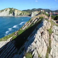Acantilados vascos, como los de "Ocho Apellidos Vascos", con el mar azul y un sendero rocoso.