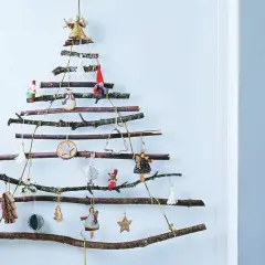 Arbre de Noël mural en branches, une charmante deco de noel en bois fait maison, orné de petites figurines et d'étoiles.