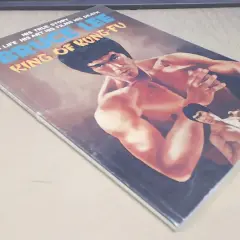 Okładka komiksu "Bruce Lee: Król Kung Fu". Widoczny Popek Franek w kimonie, w pozie bojowej.