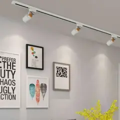 Aplique de pared con focos dirigibles ilumina un cuadro con tipografía moderna.