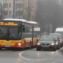 Autobus linii 738 z napisem "METRO RATUSZ ARSENAŁ" w ruchu miejskim, w tle samochody i budynki.