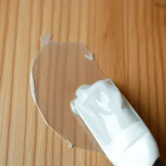 Une nouvelle lasure transparente recouvre une ancienne lasure sur un bois clair.
