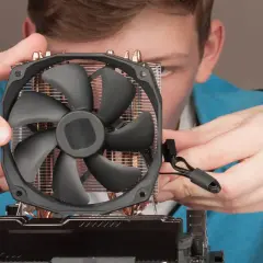 Junge Person montiert CPU-Kühler. Möglicher Fehler: cpu fan speed detection error.