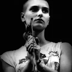 Sinéad O'Connor śpiewa "Nothing Compares 2 U", jej twarz jest oświetlona, a ona trzyma mikrofon.