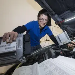 Técnico con gafas revisa unidades de control para modificaciones coche.