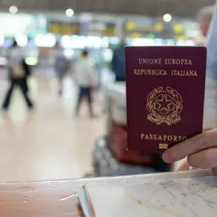 Włoski paszport w dłoni, gotowy do podróży po krajach bez paszportu w strefie Schengen.