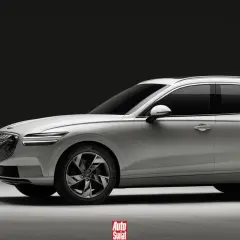 Biały Genesis GV70 na ładowarce. Elegancki SUV z charakterystycznym grillem i podwójnymi światłami.