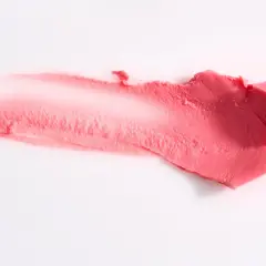 Smuga różowej pomadki, która może zawierać methylparaben, na białym tle.