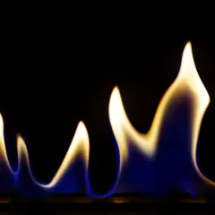 Blau-gelbe Flammen tanzen im Dunkeln, eine Warnung vor den ethanol gefahren.