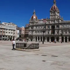 La **plaza María Pita** luce soleada con su ayuntamiento monumental y gente paseando.