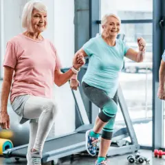 Quatre seniors souriants font de l'exercice ensemble. Voici 5 arguments pour le sport : vitalité, joie, santé, longévité et bien-être.