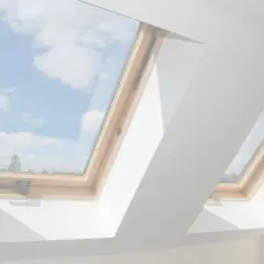 Vue du ciel bleu et des nuages à travers deux fenêtres de toit en bois. L'une est ouverte, prête à changer l'air.