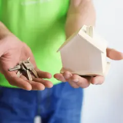 Ręce trzymają klucze i model domu. Zastanawiasz się, na co zwrócić uwagę przy umowie najmu?