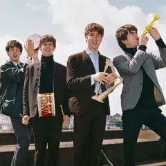 The Beatles w swoich eleganckich garniturach, grając na instrumentach, tworzą niepowtarzalne The Beatles utwory.