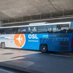 Autobus Flybuss OSL z logo samolotu, gotowy do odjazdu z lotniska Oslo.