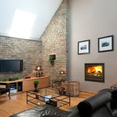 Gemütliches Fernsehzimmer einrichten mit Kamin, Ledersofa und Steinwand.