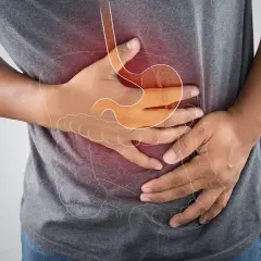 Mann hält sich den Bauch wegen eines akuten Abdomens. Die Grafik zeigt den Magen und Darm.