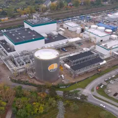 Budowa nowoczesnej elektrociepłowni, gdzie Polimex-Mostostal realizuje akcje. Widoczny ogromny zbiornik ZEC, instalacje i kominy.