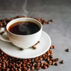 Gorące espresso otoczone ziarnami kawy. Pyszny napój, który ma znikome espresso kalorie.