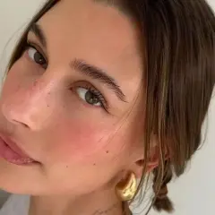 En närbild på en kvinna som har valt att applicera rouge för en naturlig, rosig look.