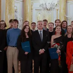Grupa młodych ludzi w eleganckich strojach odbiera stypendium artystyczne ministra kultury.