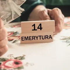 Dłonie trzymające pieniądze i kostki z napisem "14 EMERYTURA".