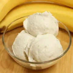 Schüssel mit cremigem Bananeneis, daneben reife Bananen. Perfekt, um Bananeneis selber machen zu können!