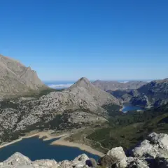 Vistas impresionantes desde el Puig de sa Rateta, con embalses y montañas escarpadas bajo un cielo azul.
