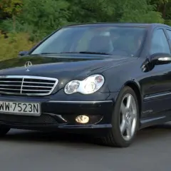 Czarny Mercedes W203 1.8 Kompressor w ruchu, z widocznym grillem i reflektorami.