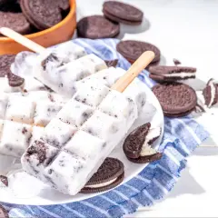 Domowe lody Oreo na patyku, otoczone ciasteczkami Oreo, wyglądają pysznie i orzeźwiająco.