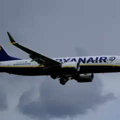 Samolot Ryanair z logo i napisem "RYANAIR" na tle chmur. Czyżby pasażerowie planowali Ryanair zmiana nazwiska?