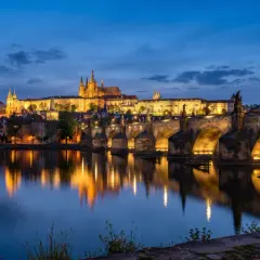 Idealny pomysł na praga na weekend: nocny widok na Most Karola i Zamek Praski, z odbiciem świateł w Wełtawie.