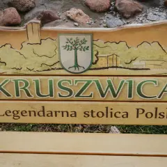 Drewniana ławka z napisem "Kruszwica Legendarna stolica Polski" i malowidłem nawiązującym do szlaku piastowskiego.