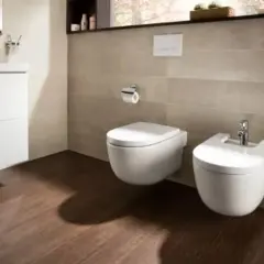 Nowoczesna łazienka z wiszącym wc i bidetem. Jest sporo miejsca na swobodne poruszanie się.