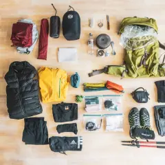 Alles für eine Trekking-Tour: Rucksack, Zelt, Schlafsack, Kleidung, Schuhe, Kochutensilien und Wanderstöcke.